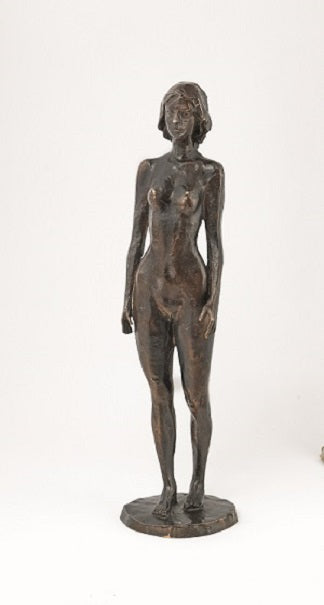 Bronzeskulptur einer nackten Frau, die aufrecht auf einem runden Sockel vor einem schlichten Hintergrund steht.