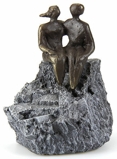 Bronzeskulptur zweier abstrakter Figuren, die auf einem strukturierten grauen Felsen sitzen, eine davon mit einem schnabelartigen Gesicht.