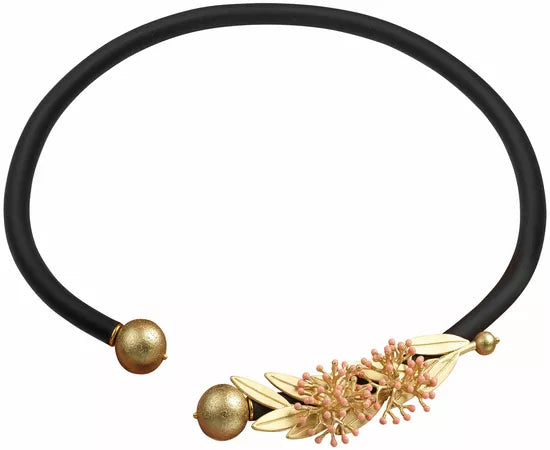 Anna Mütz: Das Collier „Oleander“ ist eine schwarze Choker-Halskette mit goldenen Endkappen und einem floralen Mittelstück in Gold und Rosa.