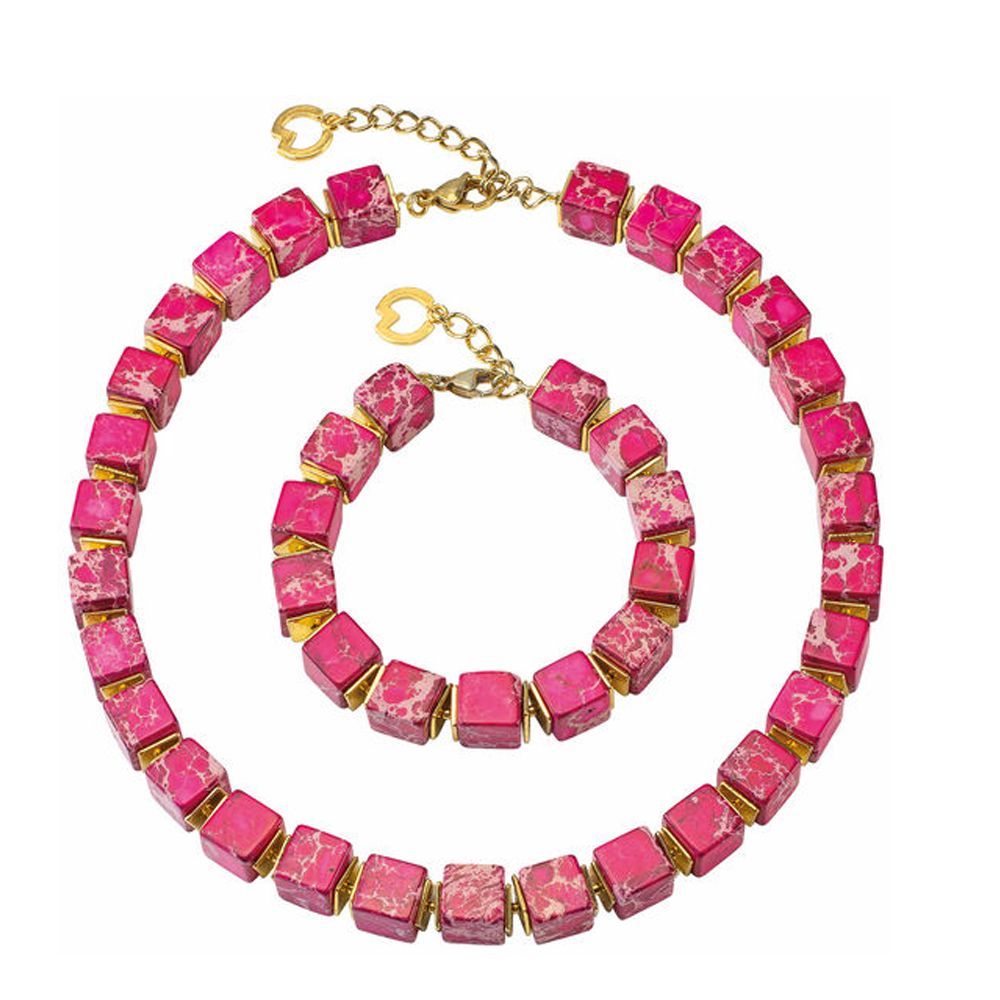 Eine Halskette aus rosa und goldenen Würfelperlen und ein passendes Armband mit herzförmigen Verschlüssen.