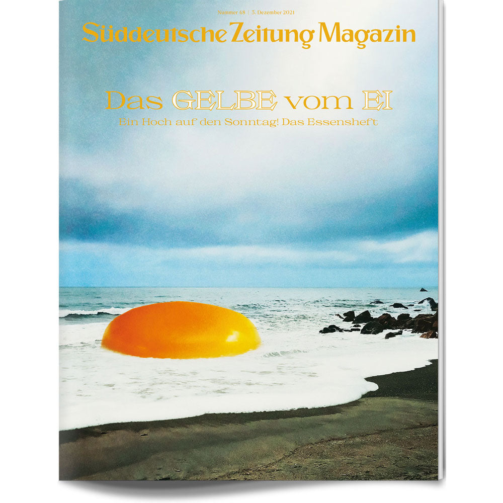 Ein riesiges Eigelb liegt an einem Strand in der Nähe des Ozeans unter einem wolkenverhangenen Himmel, Titeltext der Zeitschrift oben.
