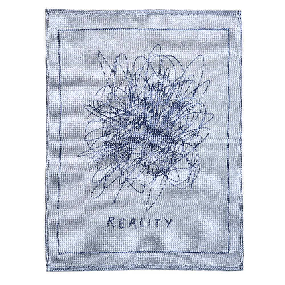 Eine blau-graue Decke mit einem Kritzeleienmuster und dem Wort REALITY darunter.