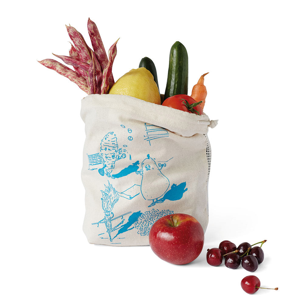 Eine wiederverwendbare Tasche gefüllt mit Gemüse und Obst, daneben ein Apfel und Kirschen auf weißem Hintergrund.