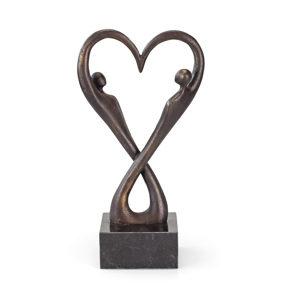 Bronzeskulptur zweier abstrakter Figuren, die eine Herzform bilden, montiert auf einem schwarzen quadratischen Sockel.