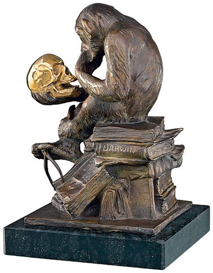 Ein bronzener Affe sitzt auf Büchern mit der Aufschrift „Darwin“ und hält in nachdenklicher Pose einen goldenen menschlichen Schädel.