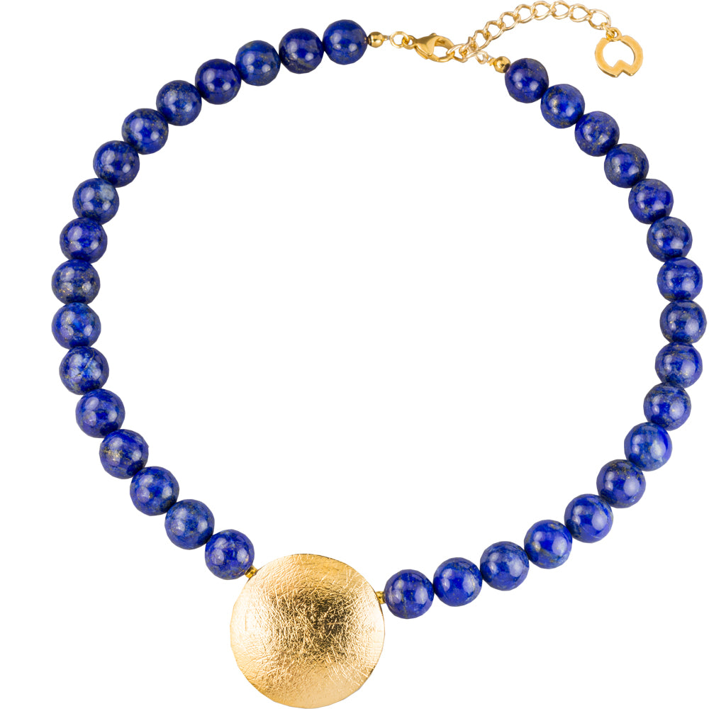 Blaue Perlenkette mit einem großen strukturierten Goldanhänger und einem Goldverschluss auf weißem Hintergrund.