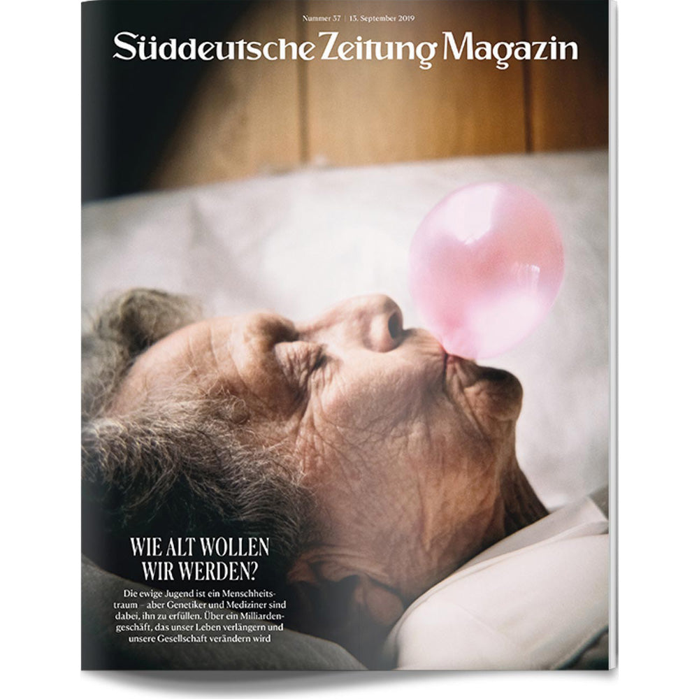 Eine ältere Person, die sich hinlegt, pustet eine rosafarbene Bubblegum-Blase auf einem Zeitschriftencover.