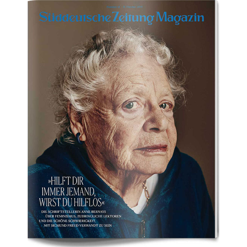 Ältere Frau mit grauen Haaren und blauen Augen blickt in die Kamera, abgebildet auf einem Zeitschriftencover mit deutschem Text.