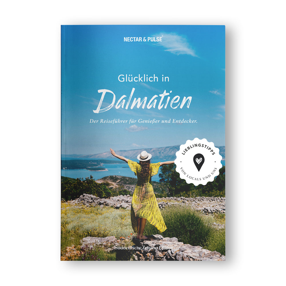Auf dem Cover eines Dalmatien-Reiseführers steht eine Frau mit Hut und erhobenen Armen und blickt auf das Meer.