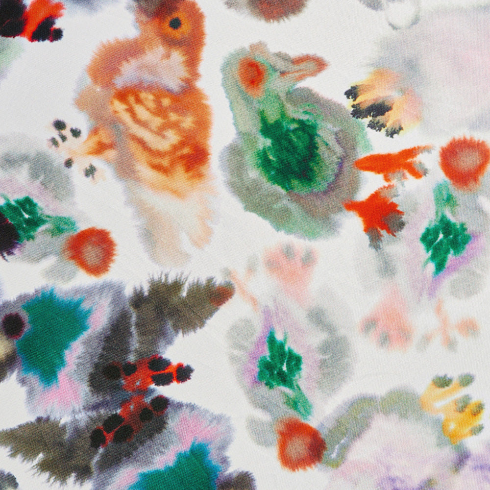 Bunte abstrakte Aquarellflecken auf weißem Papier, die Grün-, Orange-, Schwarz- und Rottöne vermischen.