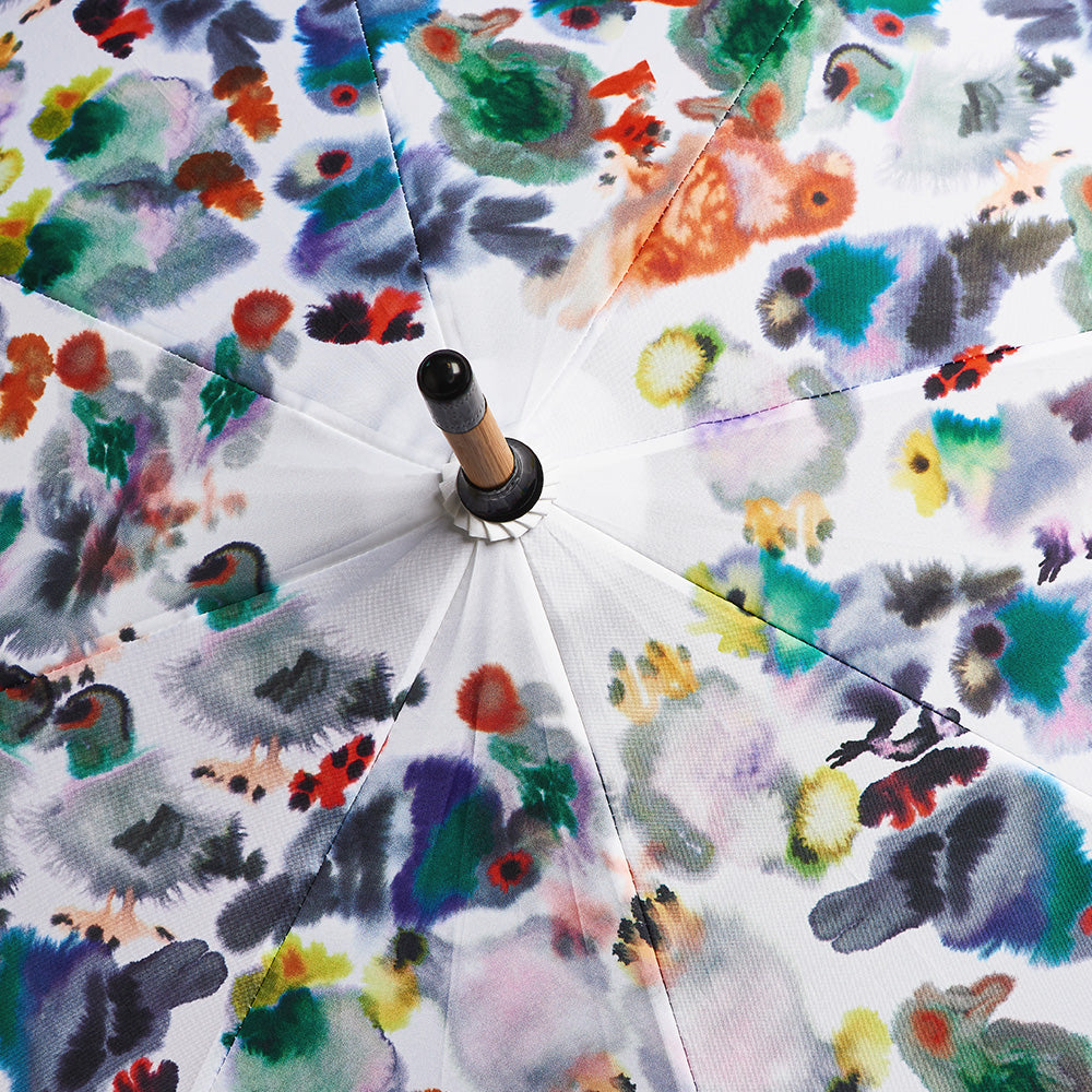 Offener Regenschirm mit farbenfrohen, abstrakten Aquarellmustern auf weißem Hintergrund, von oben betrachtet.