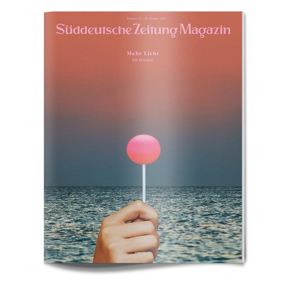 Auf dem Titelbild einer Zeitschrift hält eine Hand einen rosafarbenen Lutscher über dem Meerwasser unter einem roten Himmel.