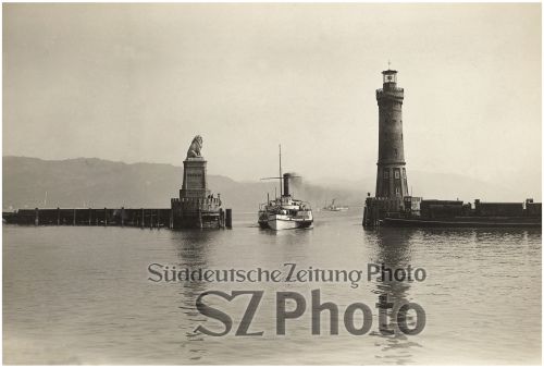 Ein Dampfschiff fährt in einen Hafen ein, der von einer Löwenstatue und einem Leuchtturm flankiert wird, mit Bergen im Hintergrund.