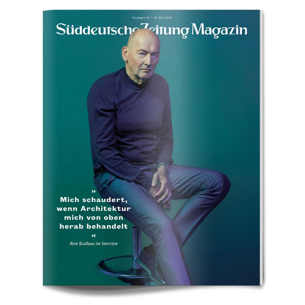 Ein Mann in dunkler Kleidung sitzt auf einem Hocker vor einem blaugrünen Hintergrund auf dem Cover des Süddeutsche Zeitung Magazins.