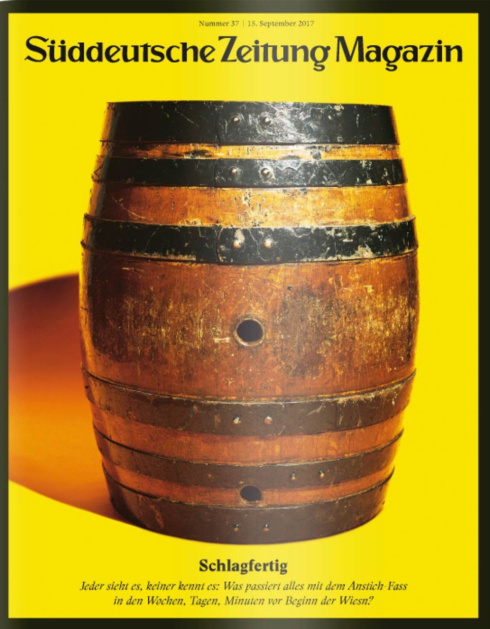 Ein hölzernes Bierfass steht aufrecht vor einem leuchtend gelben Hintergrund.