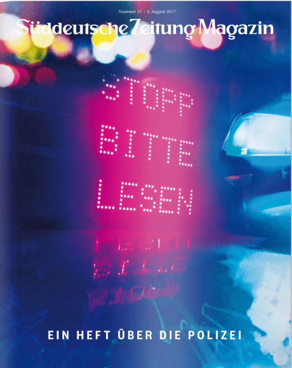 Ein Polizeiauto mit einem digitalen Schild mit der Aufschrift STOPP BITTE LESEN auf der Titelseite des Süddeutsche Zeitung Magazins.
