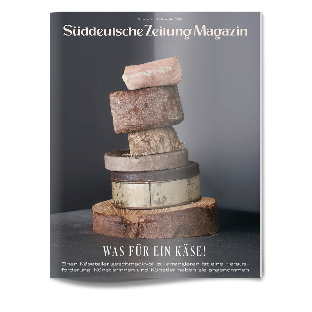Ein Stapel verschiedener Käsesorten ist auf einer dunklen Fläche angeordnet, die auf einem Zeitschriftencover abgebildet ist.