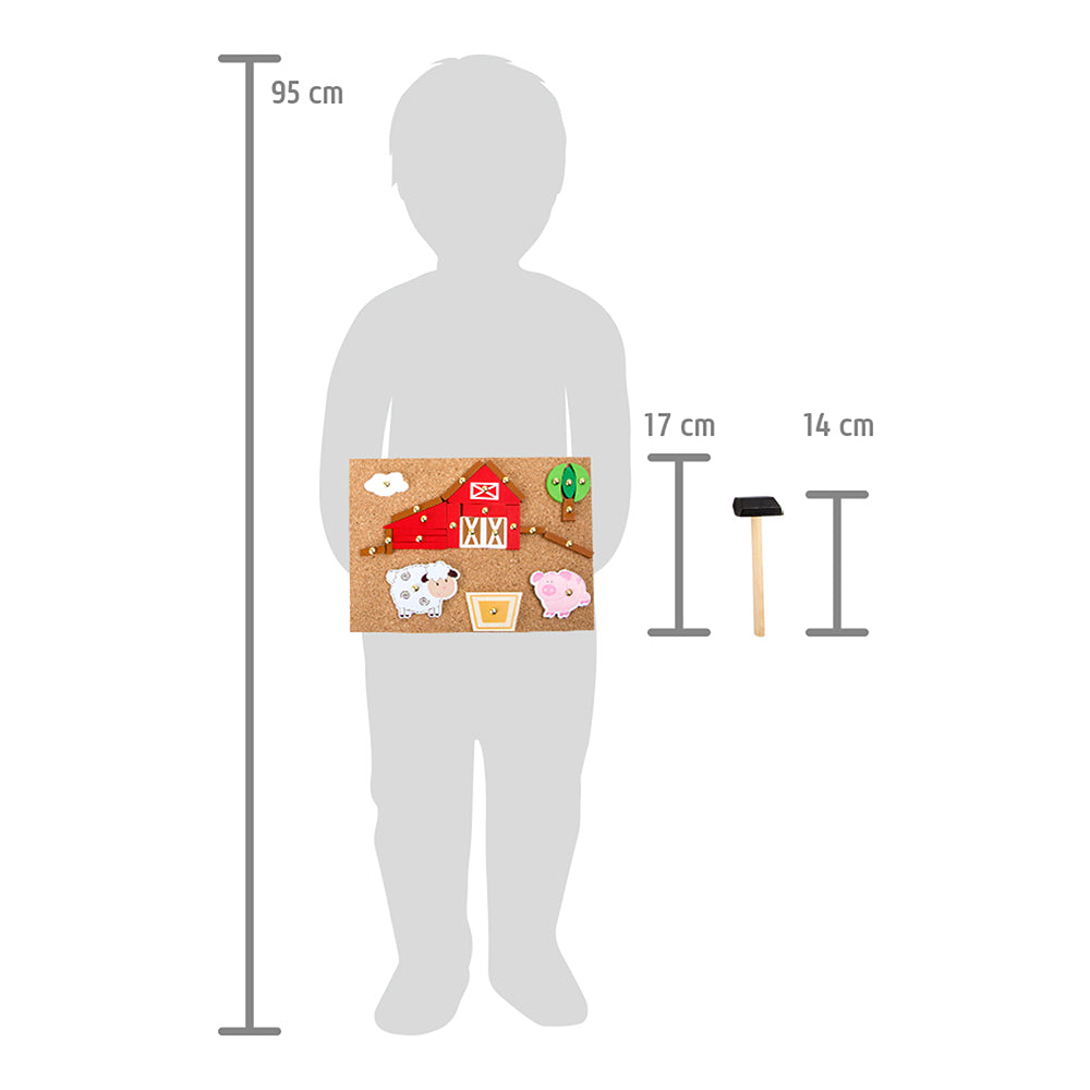 Eine Kindersilhouette hält das Hämmerchenspiel Bauernhof-Brett mit den Bauernhoftier-Spielsteinen; das Brett misst 17 cm und der mitgelieferte Hammer ist 14 cm lang.