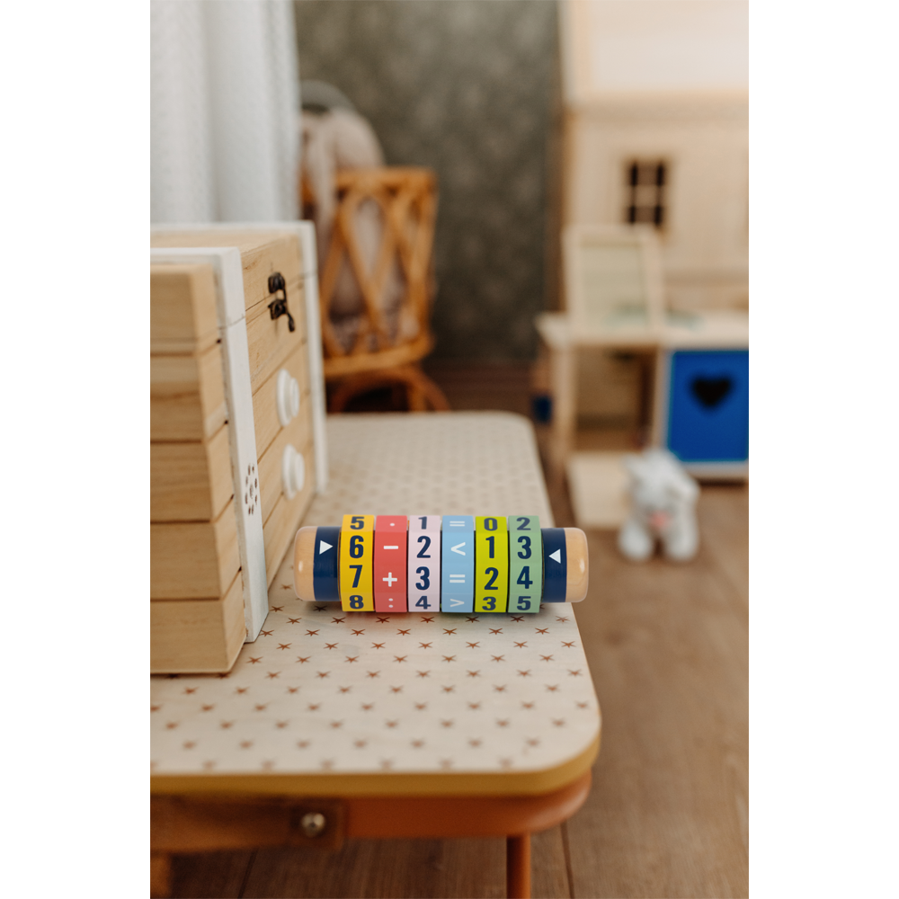 Die Rechenrolle Kleines 1x1 „Educate“ ist ein farbenfrohes Mathematikspielzeug aus Holz mit Zahlen und Symbolen, perfekt zum Lernen im gemütlichen Spielzimmer.