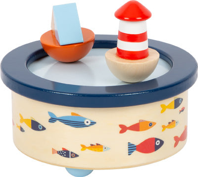 Spieluhr Großer Ozean: Hölzerne Spieluhr mit bunten Fischen, einem rot gestreiften Leuchtturm und einem kleinen Boot oben drauf.