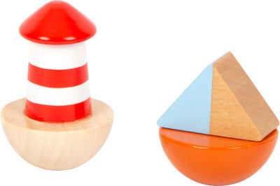 Die Spieluhr Großer Ozean besteht aus zwei Stapelspielzeugen aus Holz: einem rot-weißen Leuchtturm und einer blau-orangen geometrischen Form.