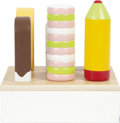 Eis am Stiel „frisch“: Enthält einen hölzernen Eisriegel, gestapelte Macarons und ein gelbes Eis am Stiel auf einem Holzsockel.