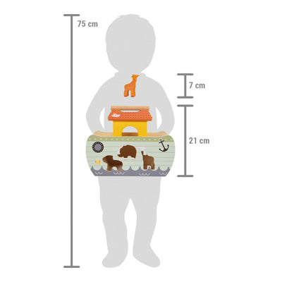 Ein 75 cm großes Kind hält das Steckspiel Arche Noah „Safari“ in der Hand: Die Arche ist 21 cm hoch und beinhaltet eine 7 cm große Giraffenfigur.