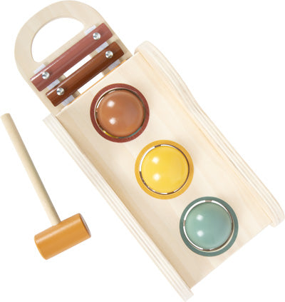 Das Klopfspiel mit Xylophon „Safari“ ist ein Holzspielzeug mit drei farbigen Kugeln und einem Hammer, mit dem die Kugeln durch die Löcher geschlagen werden können.