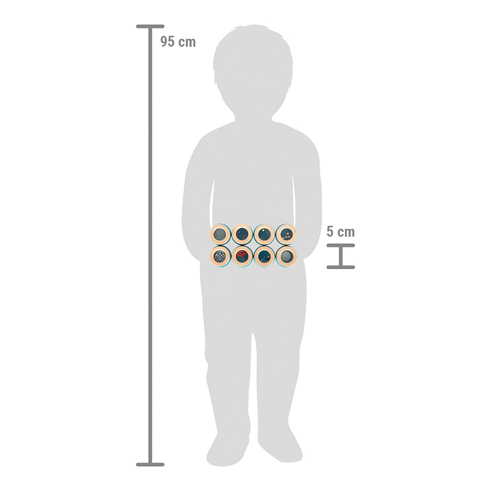 Eine graue Silhouette eines 95 cm großen Kindes hält zehn Hörmemo „Sensory“-Scheiben mit jeweils etwa 5 cm Durchmesser.