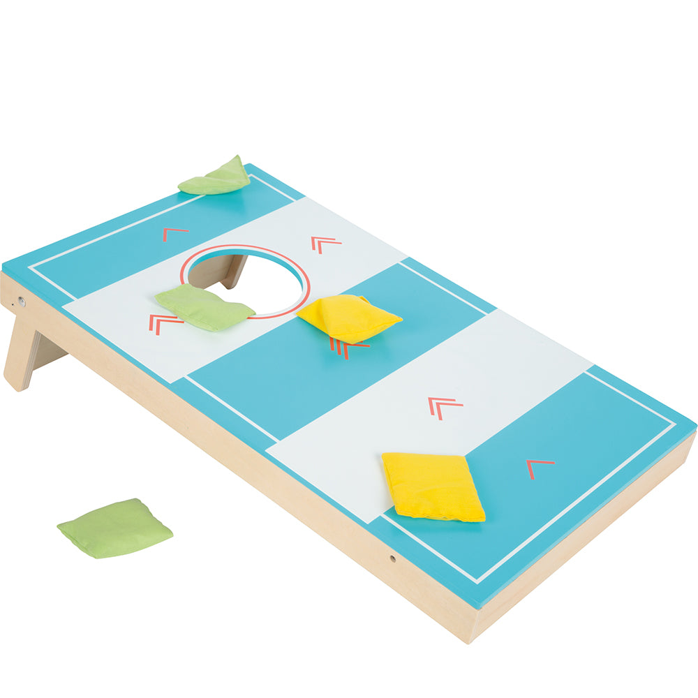 Das Cornhole und Sling Puck Spiel „Active“ verfügt über grüne und gelbe Sitzsäcke auf und um sein blau-weißes Brett.
