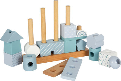 Stapelspielzeug aus Holz mit blauen, weißen und gemusterten Blöcken auf einem Holzsockel mit vertikalen Stäben.