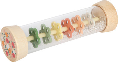 Regenmacher aus Holz mit bunten blumenförmigen Scheiben und kleinen Perlen in einem durchsichtigen Zylinder.