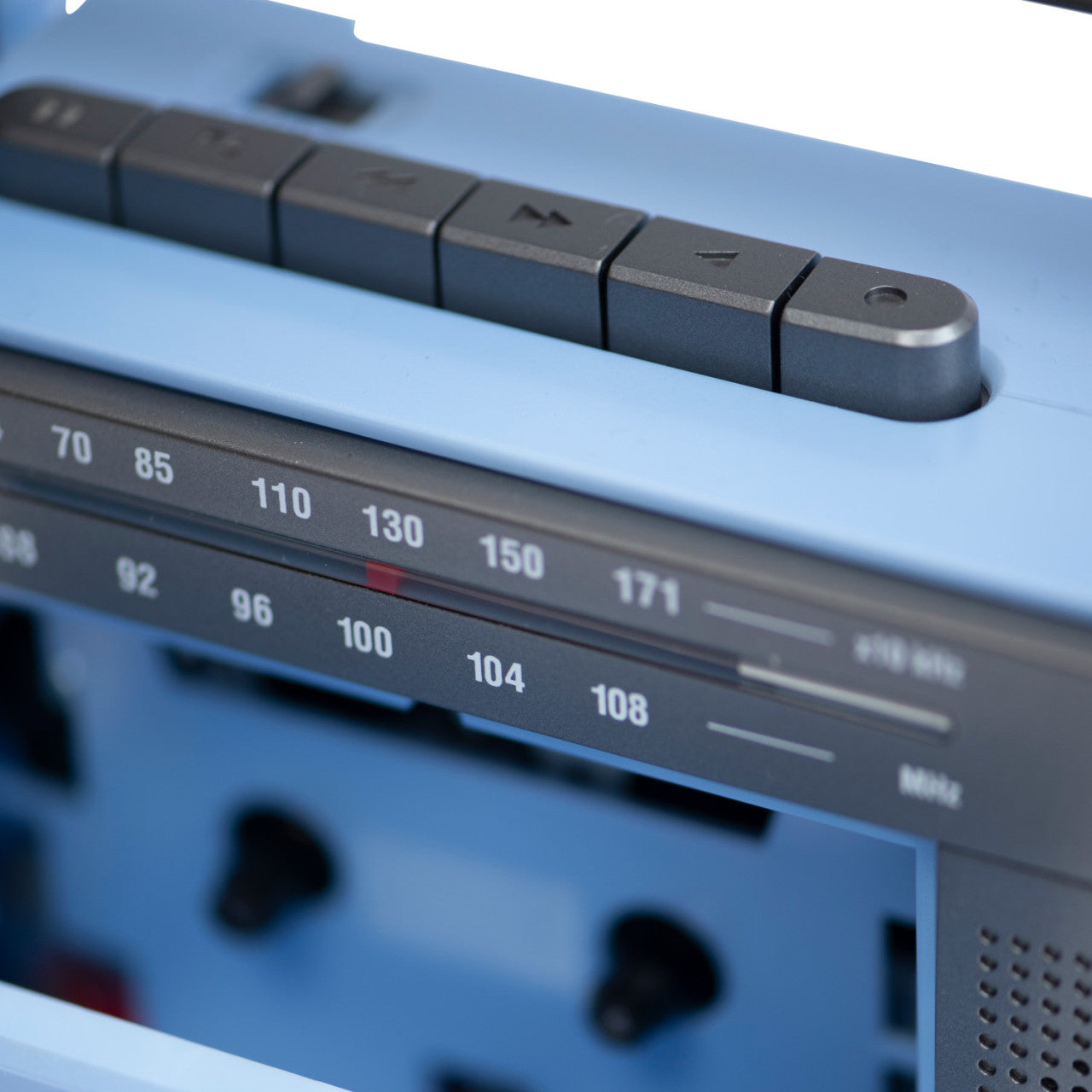 Nahaufnahme des Crosley-Kassettenspielers in Blau/Grau, mit hervorgehobenen Tasten und FM-Tuner-Regler.