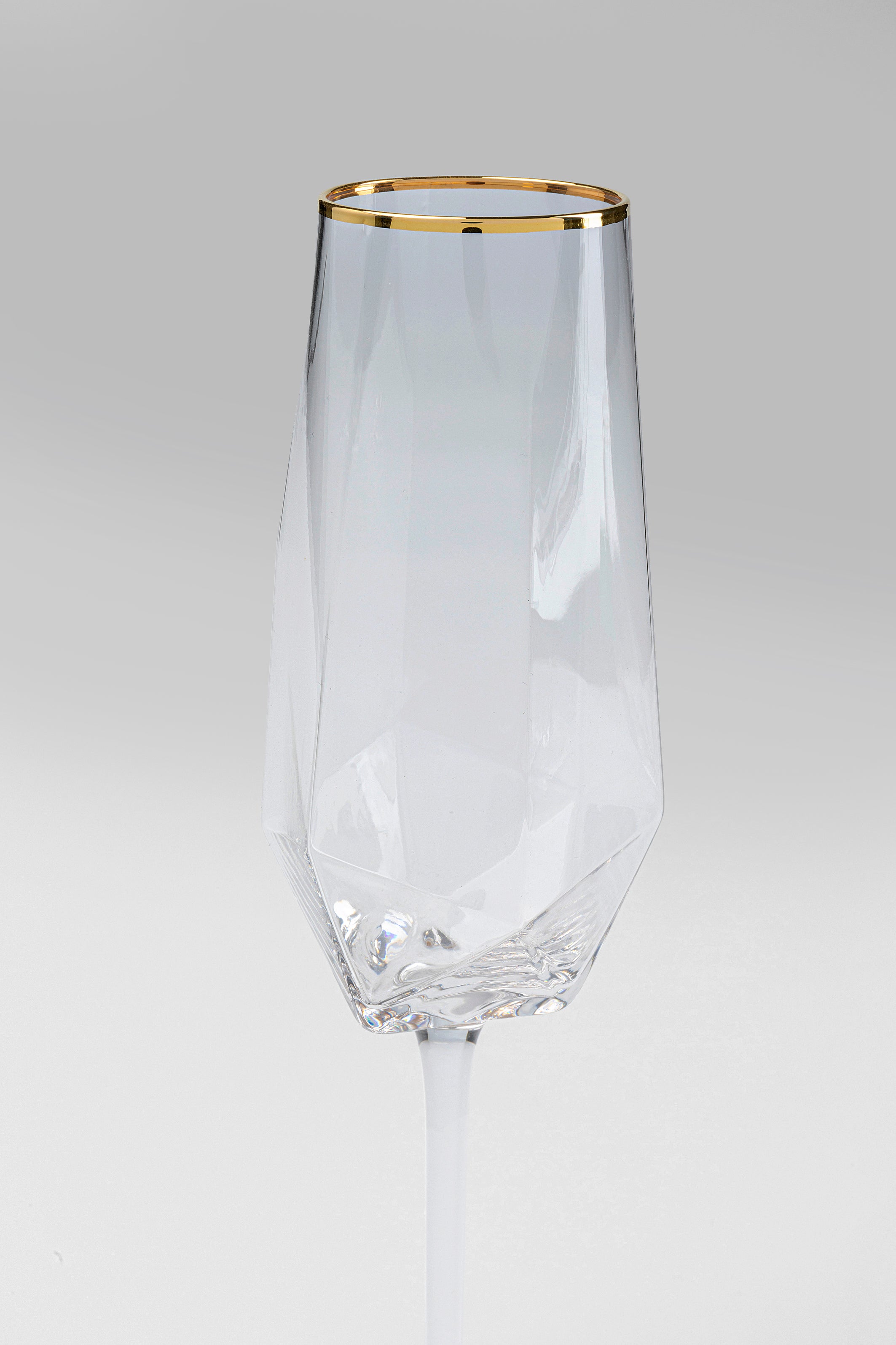 Das Sektglas Diamond Gold Rim (4/tlg.) besticht durch ein klares, facettiertes Design mit Rautenmuster und Goldrand, abgebildet auf schlichtem hellgrauem Untergrund.