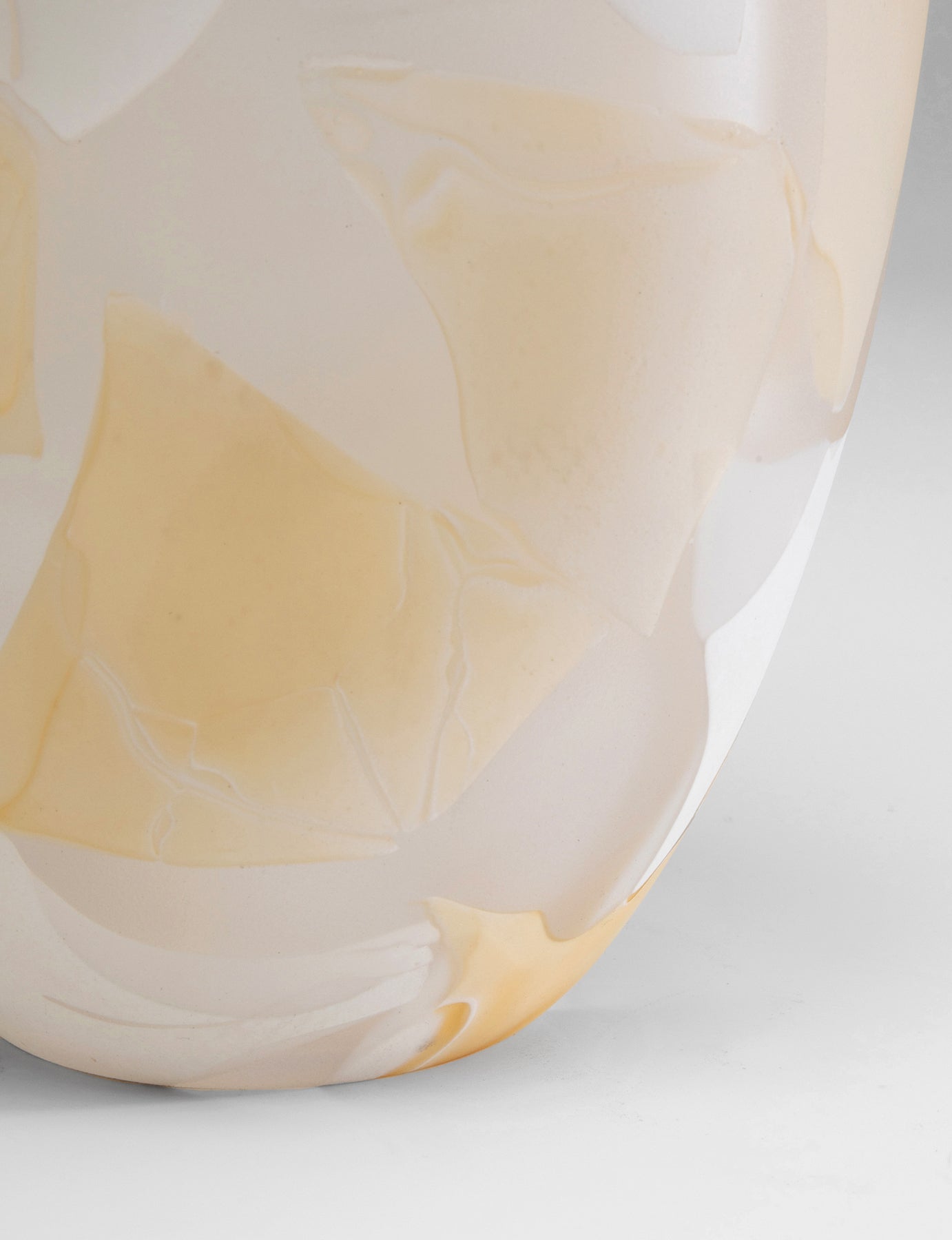 Nahaufnahme der Vase Galicia Beige: glatte weiße Keramik mit großen hellgelben, marmorartigen Flecken – perfekt als dekorativer Akzent oder zum Präsentieren von Blumenarrangements – vor einem hellgrauen Hintergrund.