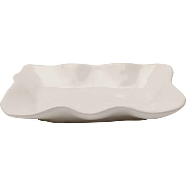 Weißer rechteckiger Keramikteller mit gewellten, unebenen Rändern, von der Seite gesehen.