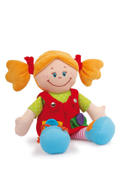 Stoffpuppe „Chiara & Massimo“: Lächelnde Stoffpuppe mit orangefarbenen Zöpfen, rotem Kleid, grünem Hemd und blauen Schuhen, sitzt aufrecht.