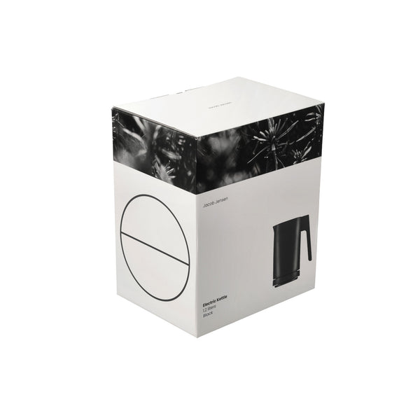 Weiße Produktschachtel mit schwarzem Bild eines Wasserkochers und minimalen schwarzen Designelementen auf der Verpackung.