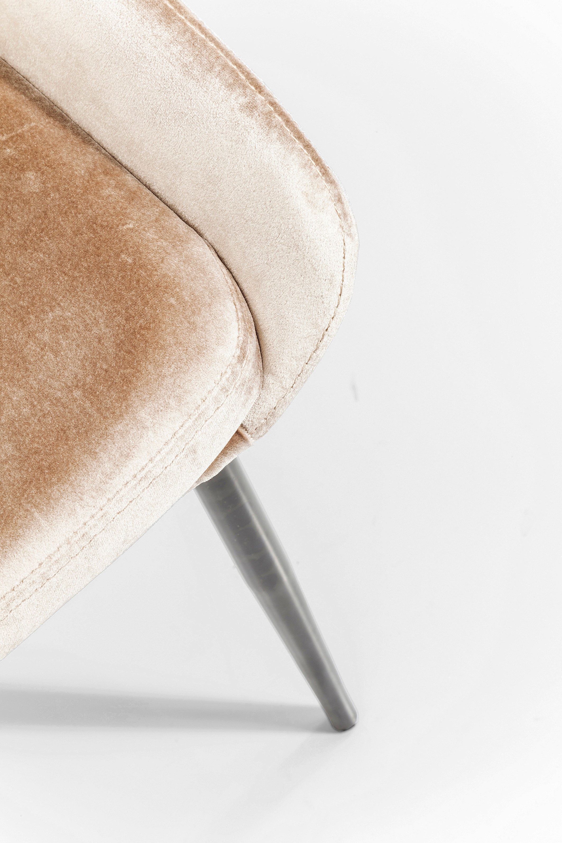 Nahaufnahme des Stuhls East Side Pearl in Beige mit gepolsterter Sitzfläche und Metallbeinen vor schlichtem weißem Hintergrund. Nur ein Teil dieses bequemen Stuhls, ideal für ein modernes Wohnambiente, ist sichtbar.