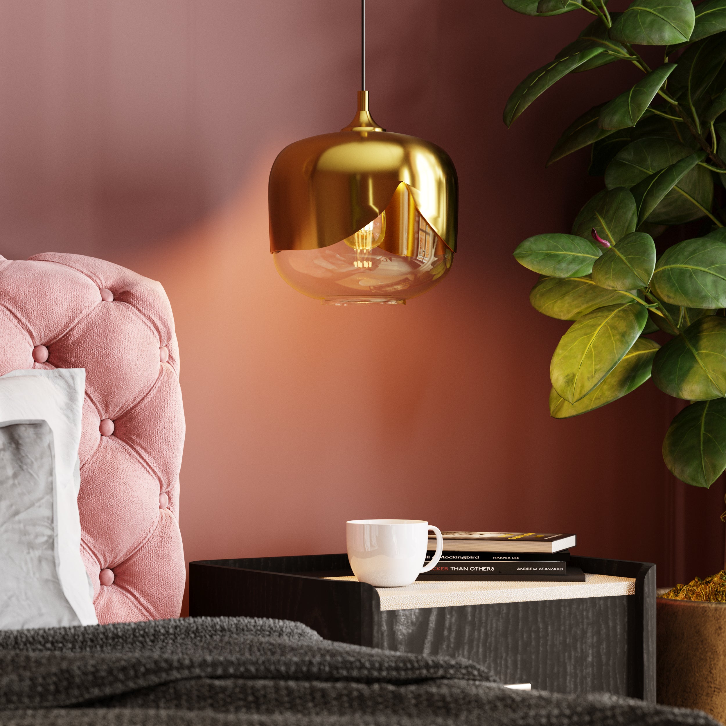 Über einem Nachttisch hängt die Hängeleuchte Golden Goblet mit einer weißen Tasse, zwei Büchern und einer großen Blattpflanze. Das Bett hat ein rosa gepolstertes Kopfteil und dunkle Bettwäsche, was eine gemütliche, stilvolle Atmosphäre schafft.