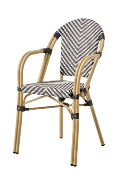 Ein Stuhl mit hellbraunem Rohrgestell, schwarzen Bindungsakzenten und einer Sitzfläche und Rückenlehne mit schwarz-weißem Chevron-Muster.