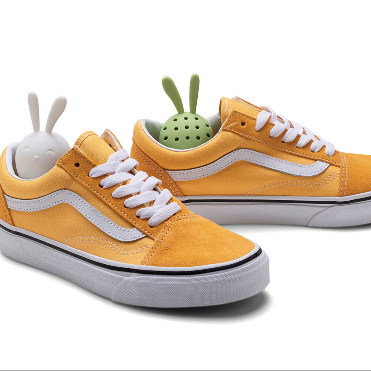 Zwei gelbe Sneaker mit weißen Schnürsenkeln, die jeweils einen Aktivkohle Schuherfrischer Sneakers Peeker in Form eines süßen Häschens in der Ferse haben.