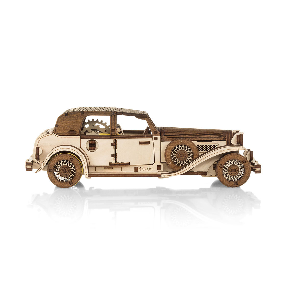 Holzmodell eines Oldtimers mit sichtbaren Zahnrädern und komplizierten Details, fotografiert auf weißem Hintergrund.
