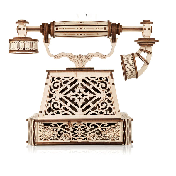 Aufwendig geschnitztes Holzmodell eines alten Drehtelefons auf weißem Hintergrund.