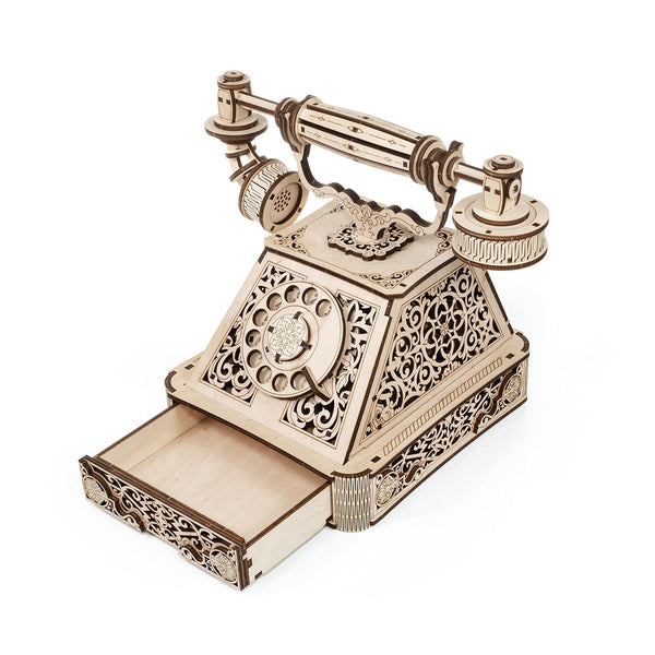 Ein hölzernes Modell eines alten Drehtelefons mit dekorativem Design und einer offenen Schublade an der Basis.