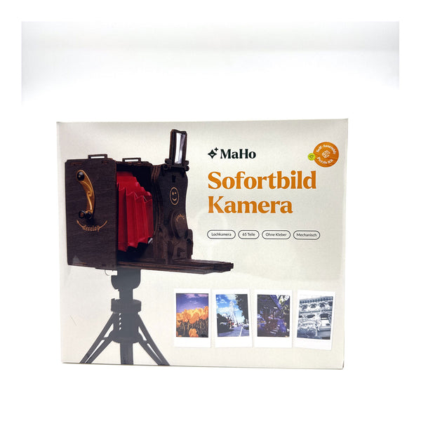 Eine MaHo Sofortbild Kamera Box mit einer Vintage-Kamera-Illustration und Beispiel-Sofortfotos auf der Verpackung.