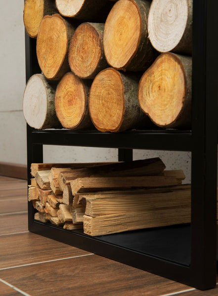 Gestapelte Brennholzscheite und gespaltenes Holz, gelagert in einem schwarzen Metallgestell auf einem Holzboden.