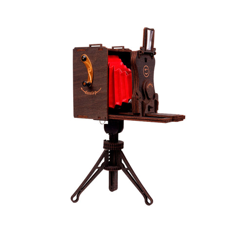 Vintage-Box-Kamera-Modell mit rotem Balg auf einem Holzstativ, isoliert auf einem weißen Hintergrund.