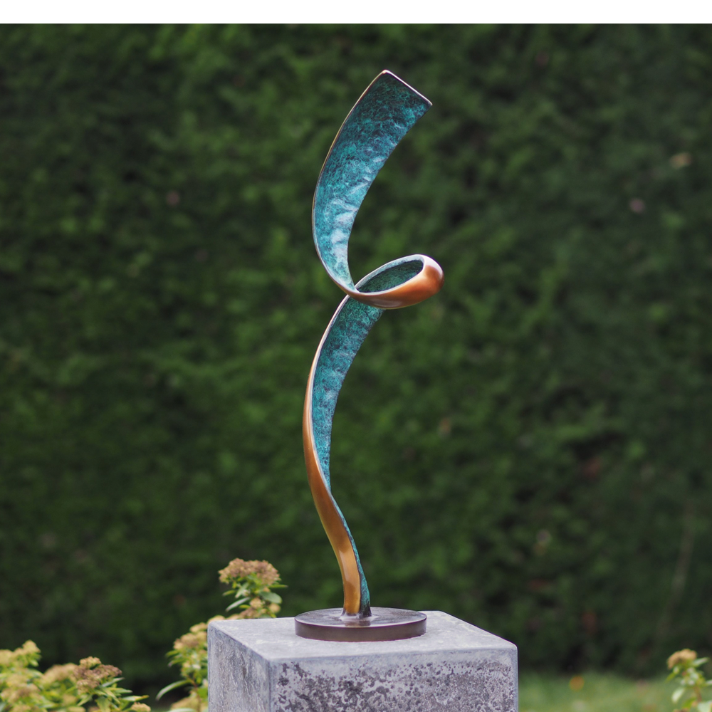 Die Gartenskulptur „Leichtigkeit des Seins“ (ohne Sockel) aus Bronze präsentiert sich in abstraktem Design vor unscharfem grünen Hintergrund.