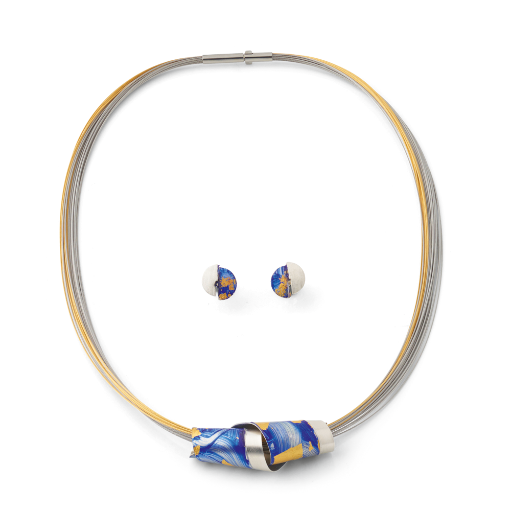 Das Kreuchauff-Design Schmuckset „Sky Dance“ besteht aus einer goldenen und silbernen Halskette mit einem blau-gelben Anhänger, gepaart mit passenden blau-weißen Ohrsteckern.